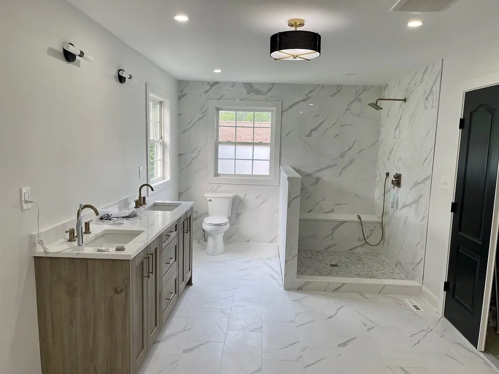 Large bathroom with walk-in shower and stone tile by Delpa Builders